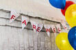 © Cavan Images - Farewell text on buntings by colorful helium balloons hanging against wall