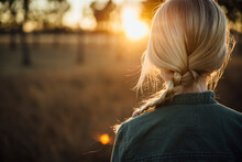 Rear View Of Girl With Braided Hair On Field During Sunset