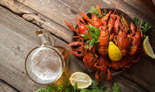 Overhead View Of Boiled Crayfish Served With Beer On Wooden Table