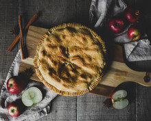 Overhead View Of Apple Pie With Fresh Ingredients On Table