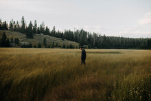 Side View Of Man Walking On Grassy Field Against Sky In Grand Teton National Park