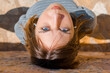 © Cavan Images - Upside-down portrait of a girl with blue eyes