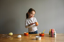 Child Paints Easter Eggs At Kitchen Table Craft