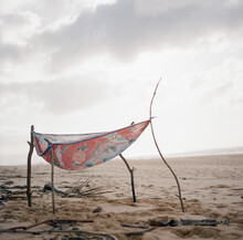 Small Handmade Stick And Colorful Fabric Fort On Cloudy Deserted Beach
