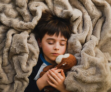 Young Sleeping Child Wrapped In Cozy Blanket With Stuffed Toy Monkey.