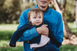 © Cavan Images - Close up of grandfather holding granddaughter outside