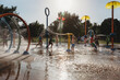 © Cavan Images - Toddler boy playing with water toy at splash pad