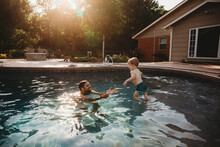 Son Jumping Into Fathers Arms In Pool