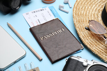 Sticker - Passport with tickets near travel items on light blue background