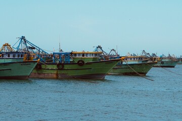 Fishing boats floating on the calm blue sea water in the Pamban island in Rameshwaram, Tamilnadu, India. Monsoon season fishing in India. Fishing boats in the harbor.