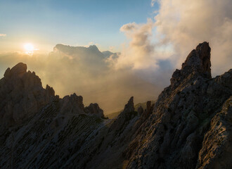 Fototapete - Sunrise in the Dolomites mountains with mist and clouds in the early morning. Fog rolling around the mountain peaks. 