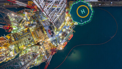 Canvas Print - Aerial view jack up rig under maintenance at night, Aerial view of jack up rig with towing vessel during towing operation, Offshore vessel in floating dock and jack up rig under repairs.
