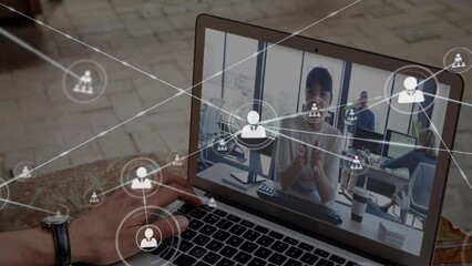 Wall Mural - Animation of network of profile icons over rear view of man having a video call on laptop at cafe