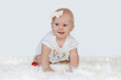 Adorable little baby girl creeping and playing in the home. White background.