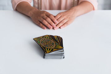 Wall Mural - KYIV, UKRAINE - JUNE 29, 2022: selective focus of tarot cards near cropped fortune teller on blurred background.