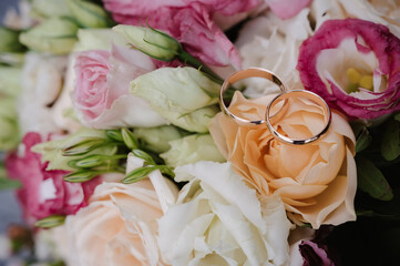 Wall Mural - pair of gold wedding rings on the bride's bouquet on the day of the ceremony