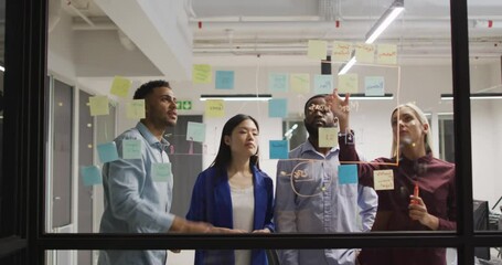 Wall Mural - video of four diverse male and female colleagues brainstorming ideas together at night in office