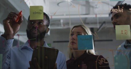 Wall Mural - video of four diverse male and female colleagues brainstorming ideas together at night in office