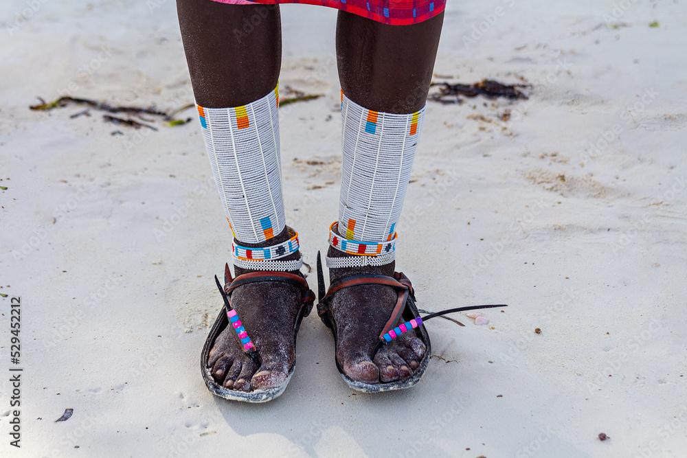 Traditional beaded jewelry on the legs of an African from the Maasai ...