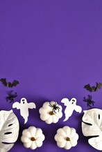 Halloween Holiday Composition With Decorations Of Pumpkins, Ghosts, Bats, Spiders And Monstera Leaves On Very Peri Purple Background.Top View, Copy Space.Happy Halloween Card. Vertical Banner 