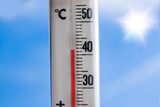 Fototapeta Mapy - a weather thermometer reaching high temperatures over 40 degrees during heat wave in europe on a very hot day with the sun and a blue sky and sun reflections in the background america asia china world