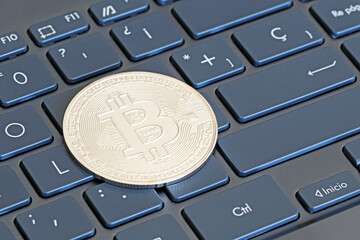 A bitcoin currency on a computer keyboard