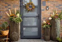 Beautiful Porch Of Residential House Decorated For Autumn With Flowers And Wreath Hanging On The Door