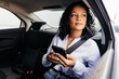 © kleberpicui - Businesswoman using smartphone in the car