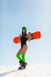 Young beautiful woman posing with a snowboard on a ski slope