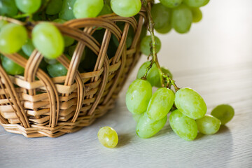 Wall Mural - green autumn ripe grapes in a basket on wooden table