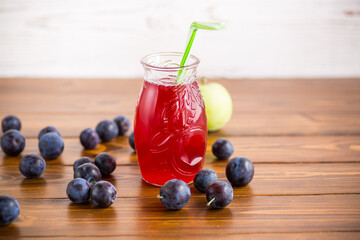 Poster - Sweet natural plum drink in a glass with a straw