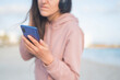 © Sheviakova - girl holding phone smartphone in hands on the seashore