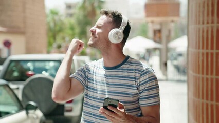 Poster - Young hispanic man listening to music and dancing at street