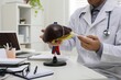 © New Africa - Doctor demonstrating model of liver at table in clinic, closeup