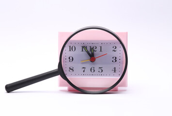 Wall Mural - Square table clock through a magnifying glass on a white background