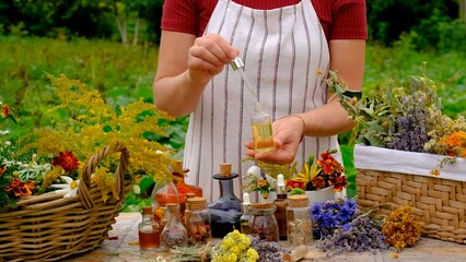 Wall Mural - Woman makes tincture with medicinal herbs. Selective focus.