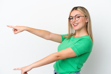 young caucasian woman isolated on white background pointing finger to the side and presenting a prod