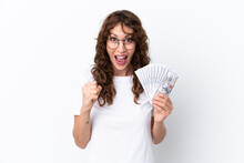 Young Woman With Curly Hair Taking A Lot Of Money Isolated Background On White Background Celebrating A Victory In Winner Position