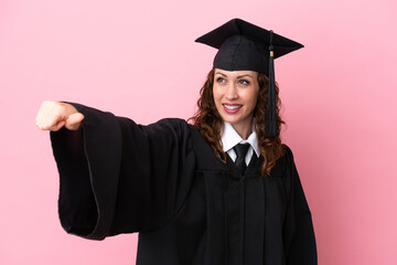 Wall Mural - Young university graduate woman isolated on pink background giving a thumbs up gesture