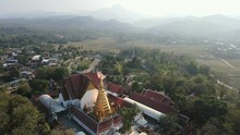 Aerial Drone View Of Beautiful Golden Pagoda At Wat Phra That Cho Hae Temple In Phrae Province, Thailand. Ancient Temple In The Middle The Jungle, Travel Destination