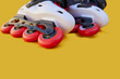 Close-up of inline skate wheels one on top of the other on a yellow background with copyspace