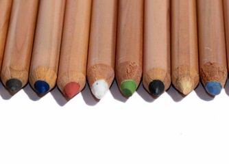 Row of colorful wooden pencils isolated on a white background