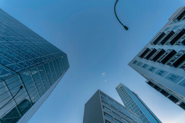 Looking up at modern houses buildings and street light pole against blue sky