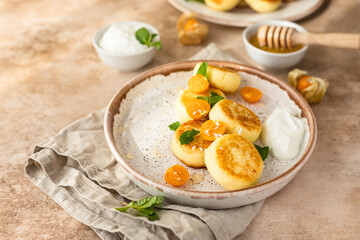 Wall Mural - Curd or ricotta fritters with physalis, honey, yogurt and mint on ceramic plate. Cottage cheese pancakes, syrniki. Healthy and tasty breakfast.