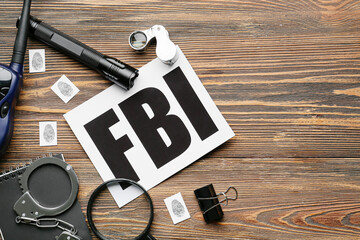 Wall Mural - Paper sheet with abbreviation FBI and accessories of agent on wooden background