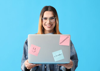 Transgender programmer with laptop on blue background