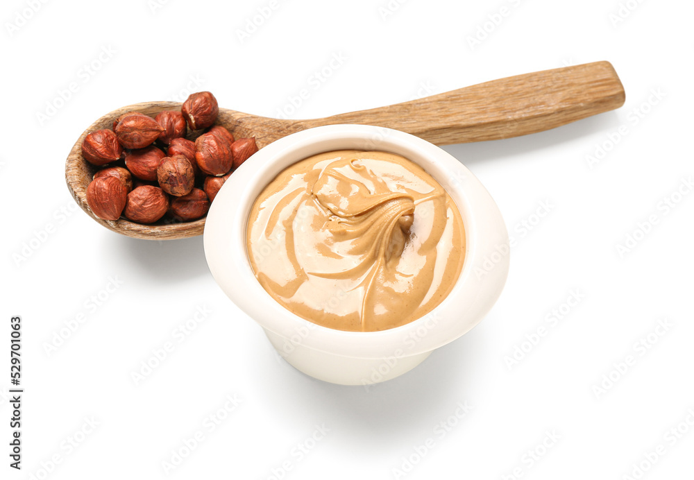 Bowl of tasty hazelnut butter on white background