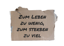Pappschild Mit Der Aufschrift "Zum Leben Zu Wenig, Zum Sterben Zu Viel"