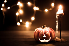 Halloween Pumpkin Wallpaper With Candle And String Lights Bokeh In The Background. Toned Vintage Colors, Copy Space.