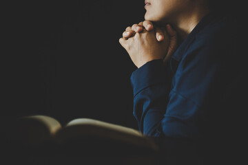 Hand folded in prayer to god on Holy Bible book in church concept for faith, spirituality and religion, woman person praying on holy bible in morning. christian catholic woman hand with Bible worship.